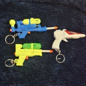 vintage and  miniature toy gun keychains, representing Laswr And Soakers 1990s